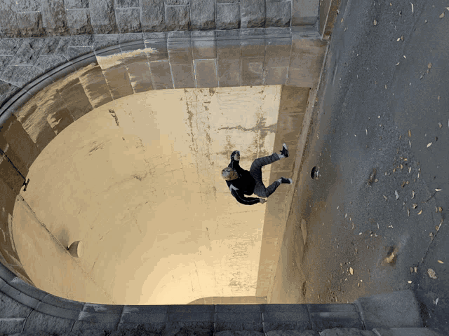 a person is doing a trick in a tunnel with a brick wall behind them
