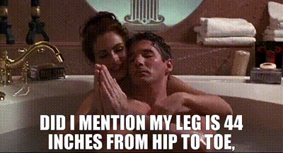 a man and a woman are sitting in a bathtub with a caption that says did i mention my leg is 44