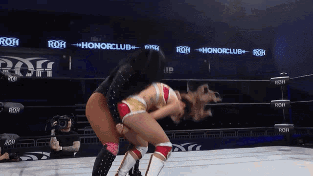 two women are wrestling in a ring that says honorclub on it
