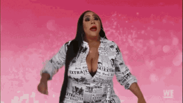 a woman is wearing a newspaper print shirt and dancing on a pink background .