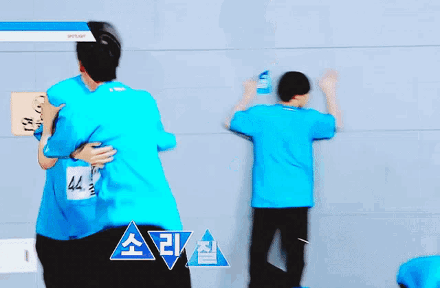 a man in a blue shirt with the number 44 on his back is hugging another man
