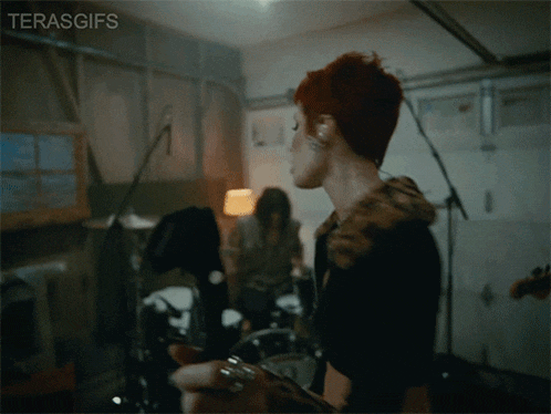 a woman with red hair is playing a guitar in a garage with the hashtag terasgifs