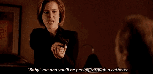 a woman is holding a gun and saying " baby " me and you 'll be peeing through a catheter