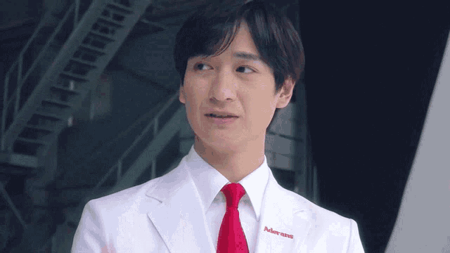 a man in a white lab coat and red tie has the word johnson & johnson embroidered on his chest