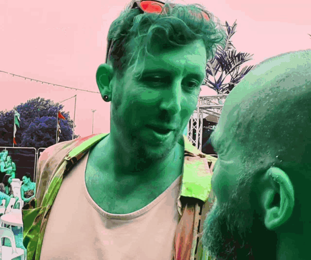 a man with a green face is talking to another man