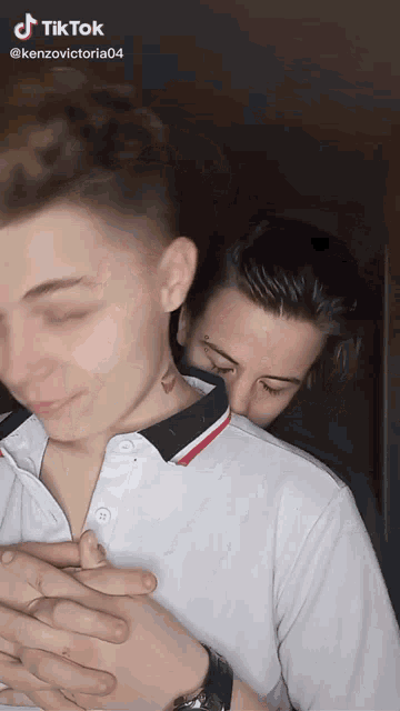 a man with a tattoo on his neck is being held by another man