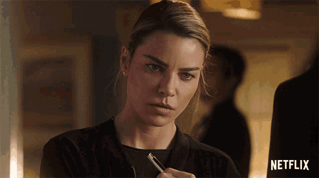 a woman holding a pen in front of a netflix sign
