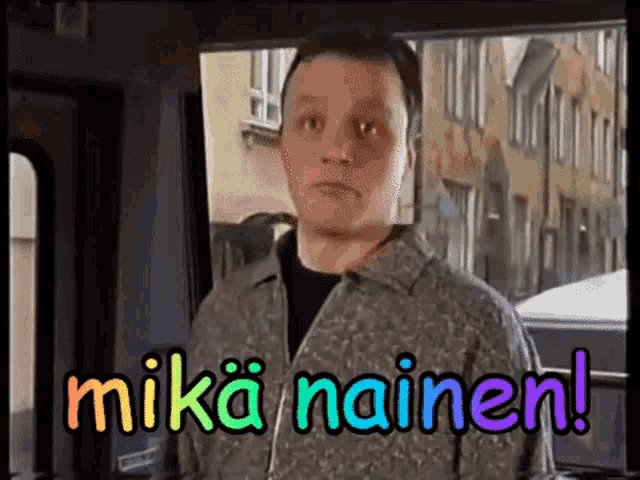 a man is standing in front of a window with the words mika nainen written on the screen