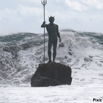 a statue of a man holding a trident is in the ocean