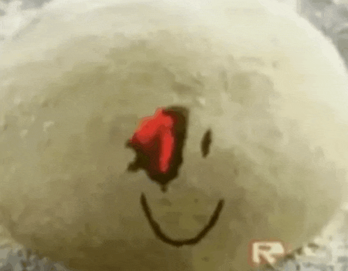 a close up of a smiley face with a red eye on a white surface .