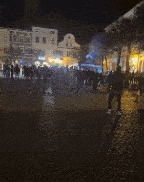 a blurry picture of people walking in a dark street at night