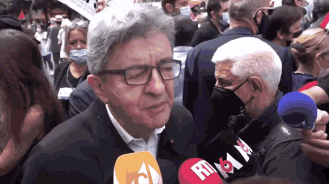 a man wearing glasses is talking into a microphone that says rt & m