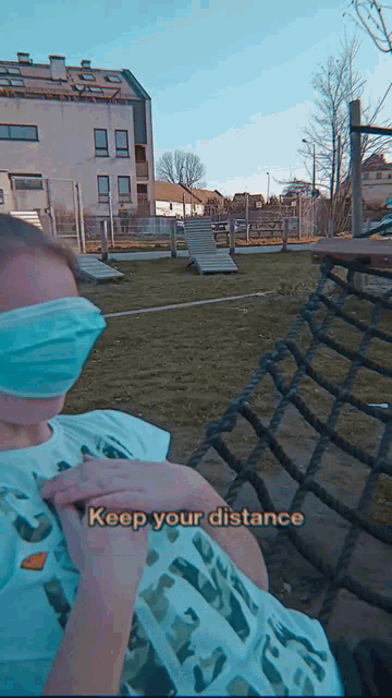 a person wearing a mask with the words keep your distance written below them