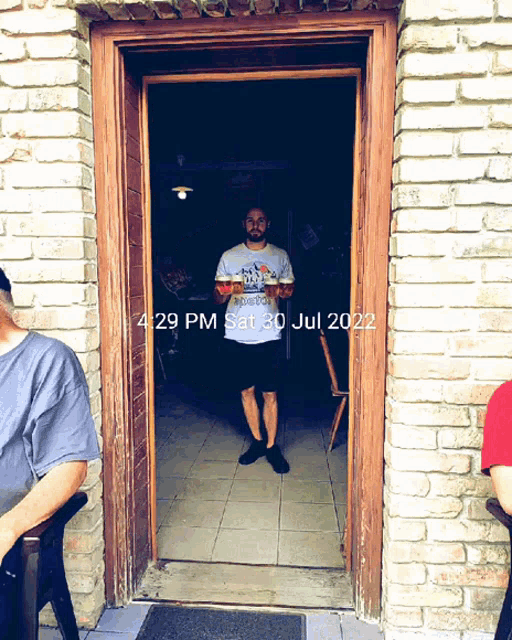 a man standing in a doorway with the date july 30 2022 on it