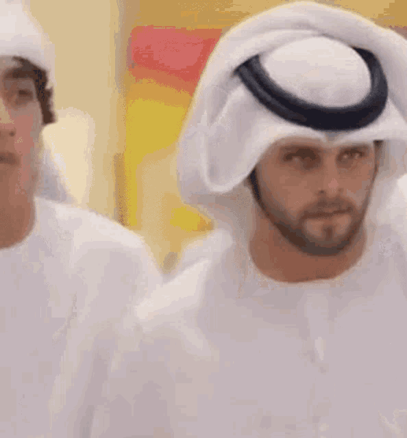 a man with a beard wearing a white turban and a white shirt .