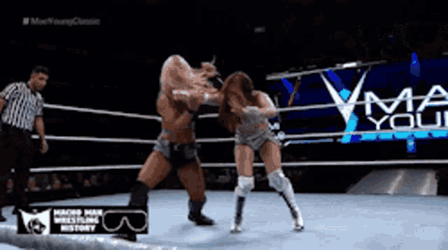 a man and a woman are wrestling in a ring with a sign that says macho man wrestling history in the background