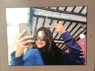 a girl is taking a selfie on a tablet with her phone