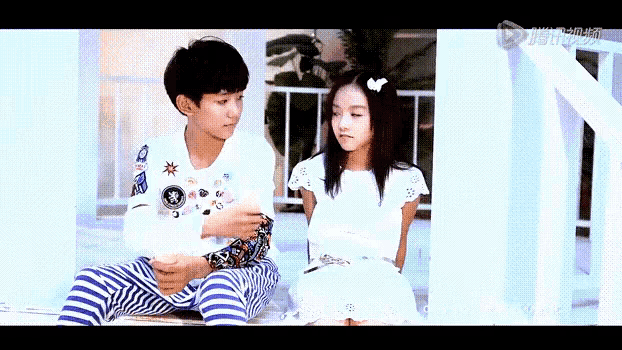 a boy and a girl are sitting next to each other