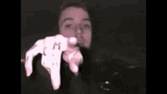 a close up of a person 's face with their hands in the air .