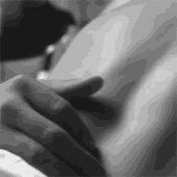 a black and white photo of a person touching their breast
