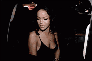 a woman in a black top is standing in a car at night .