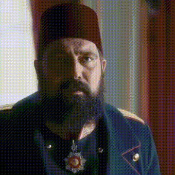 a man with a beard and a hat is wearing a uniform and medal .