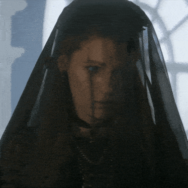 a woman wearing a black veil and a choker