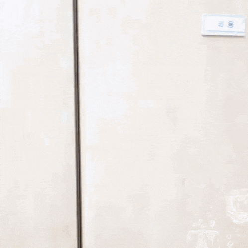 a man in a skeleton glove is peeking out of a closet .