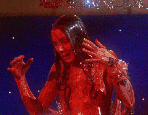 a woman with blood on her face holds her head in her hands