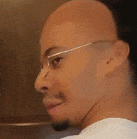 a bald man with glasses and a beard