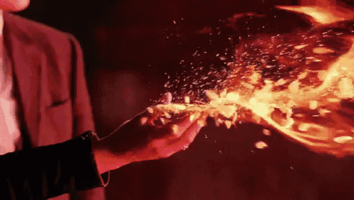 a man in a suit is holding a flame in his hand