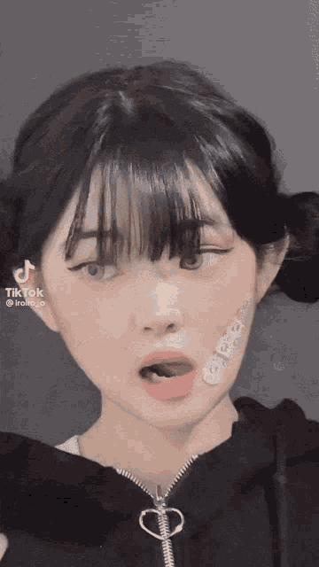 a tiktok video of a girl with pigtails and bandages on her face