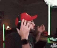 a man wearing a red hat and headphones is sitting in a room .