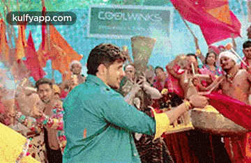 a man is standing in front of a crowd of people holding a trophy and a drum .