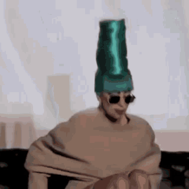 a person is wearing a green hat and sunglasses .