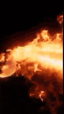 a close up of a fire in the dark with a black background