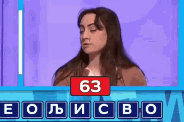 a woman is playing a game with the number 63 on the screen