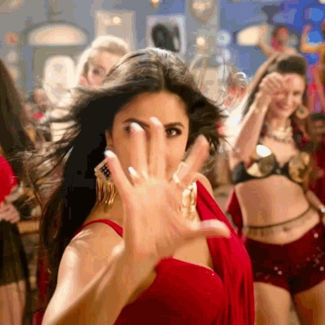 a woman in a red dress making a stop sign