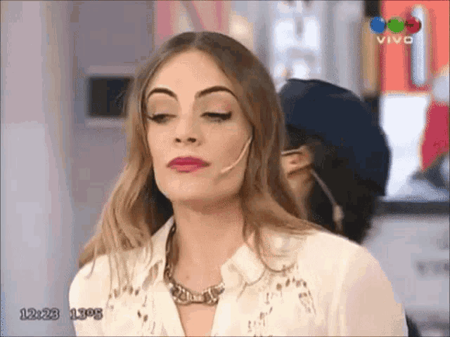 a woman with a microphone on her ear is on a live tv show