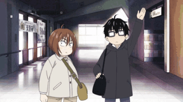 a man and a woman are standing in a hallway with a sign on the wall that says 00