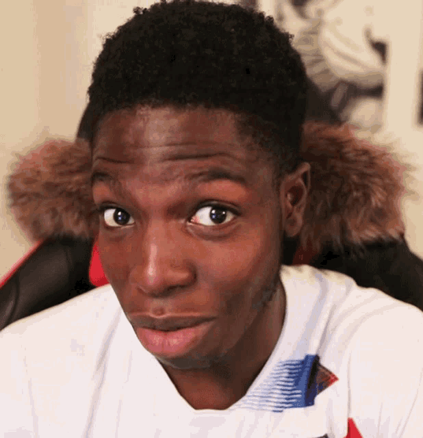 a man wearing a white shirt with a fur hood