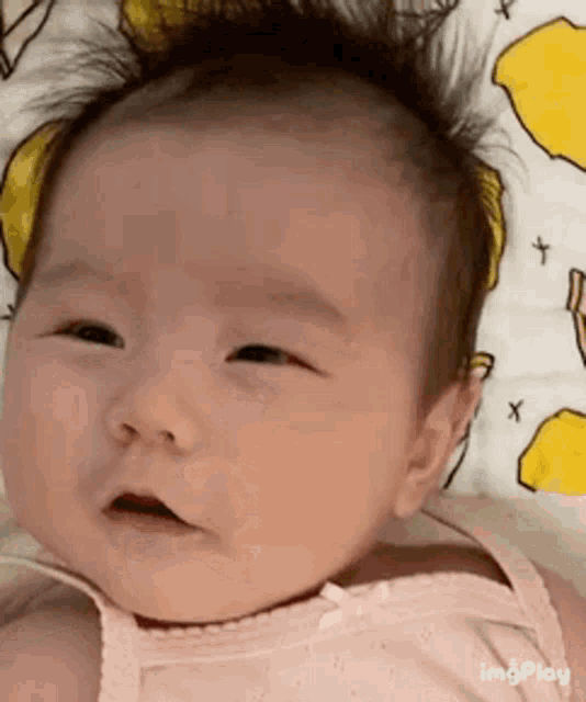 a baby is laying on a blanket with lemons on it .
