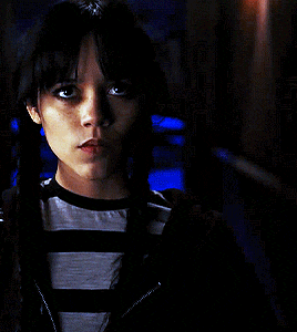 a woman with pigtails and a striped shirt is looking at the camera