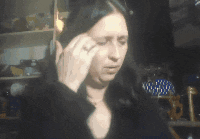a woman with a ring on her finger wipes her forehead