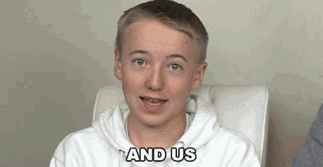 a young boy sitting in a chair with the words and us written on his face