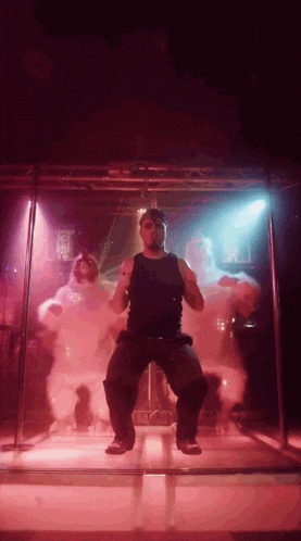 a man in a black tank top is dancing on a stage in front of a sign that says ' a ' on it