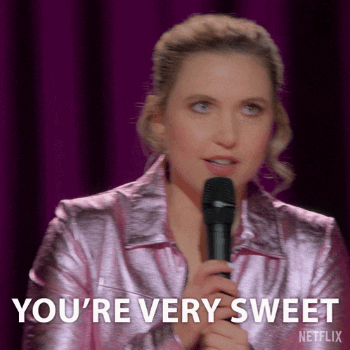 a woman in a pink jacket is holding a microphone and says you 're very sweet netflix