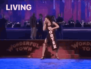 a woman in a black dress is dancing in the water with the word living above her