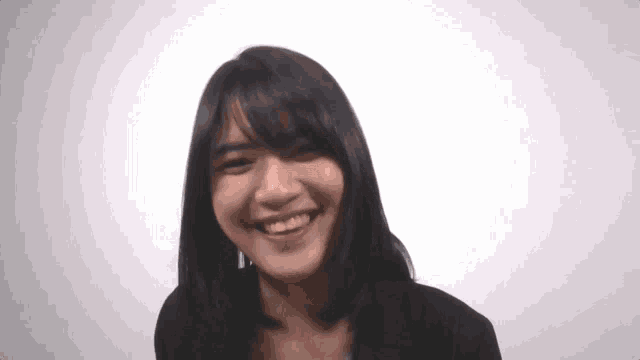 a woman is smiling and looking at the camera