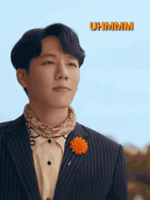 a man in a suit has an orange flower pinned to his lapel and the word uhhmm is above him